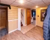 Lower level bedroom used as a transitional room featuring a drop ceiling and hardwood / wood-style flooring