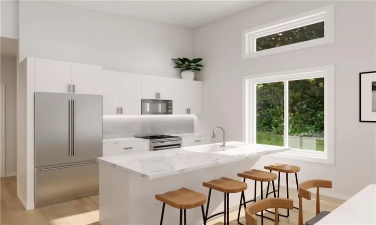 Kitchen featuring light hardwood / wood-style floors, a breakfast bar area, sink, white cabinets, and appliances with stainless steel finishes