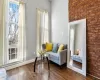 Living area featuring brick wall and dark hardwood / wood-style flooring