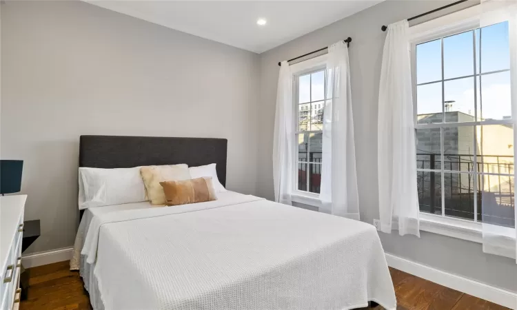 Bedroom with dark hardwood / wood-style flooring