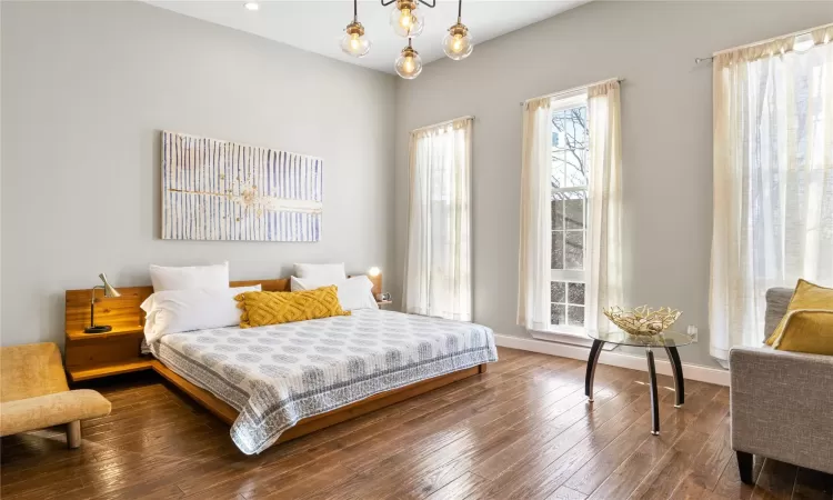 Bedroom featuring an inviting chandelier and hardwood / wood-style floors