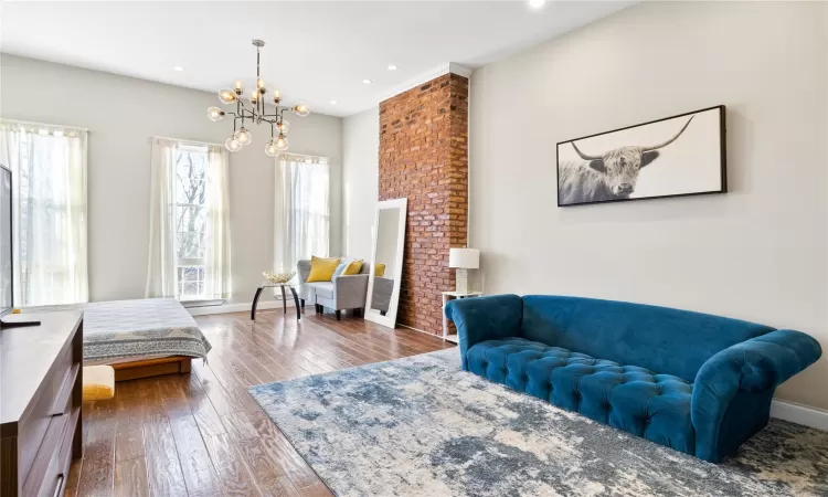 Bedroom with hardwood / wood-style flooring and a notable chandelier