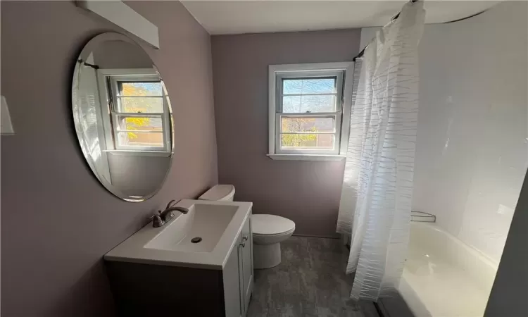 Full bathroom featuring vanity, toilet, shower / bath combo, and hardwood / wood-style floors