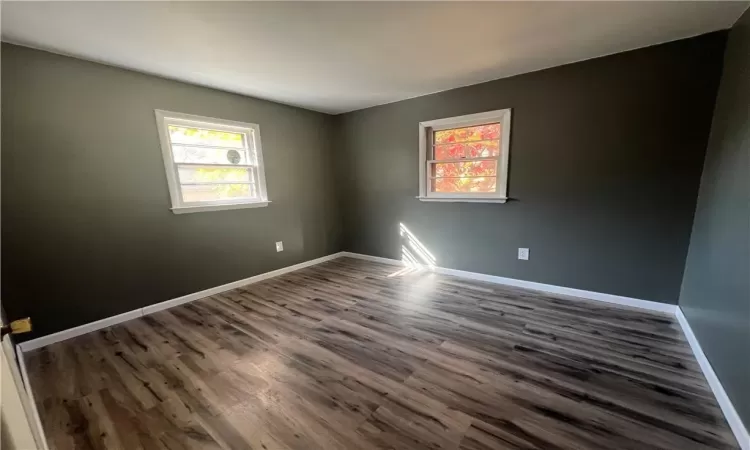 Empty room with dark wood-type flooring