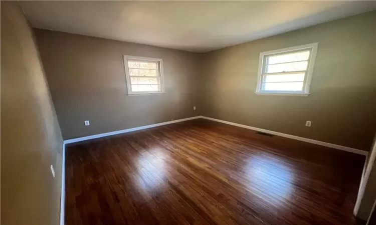 Empty room featuring dark wood-type flooring