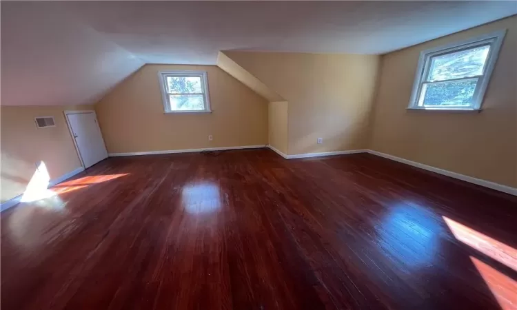 Bonus room featuring vaulted ceiling and dark hardwood / wood-style flooring