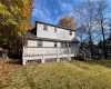 Back of property featuring a deck and a lawn