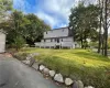 Rear view of house with a wooden deck and a yard