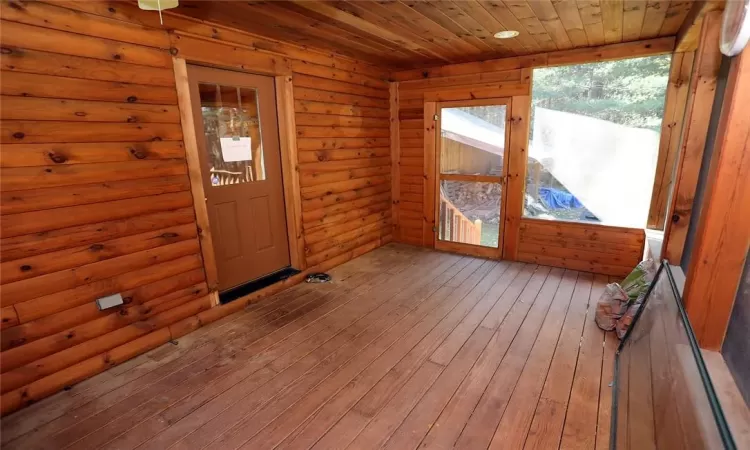 Unfurnished sunroom with wooden ceiling