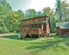 Back of property with a wooden deck and a lawn