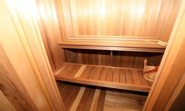 View of sauna / steam room with wood walls and hardwood / wood-style flooring