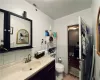 Bathroom featuring toilet, vanity, and tile walls