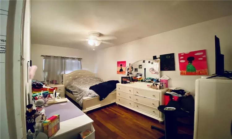 Bedroom with dark wood-type flooring and ceiling fan