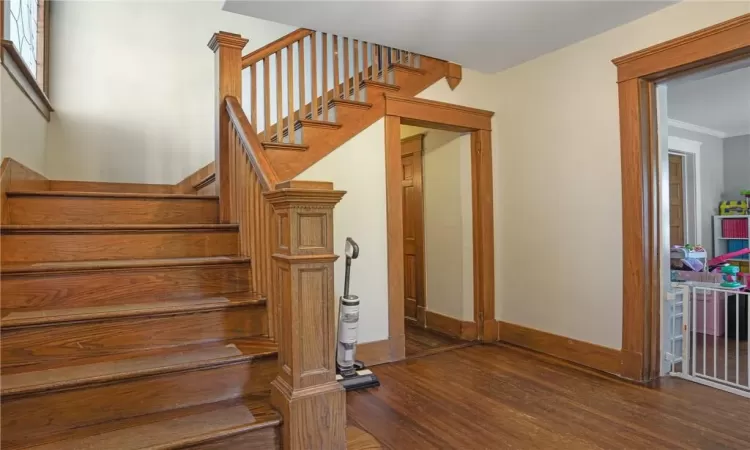 Staircase featuring ornamental molding and hardwood / wood-style flooring