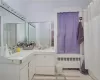 Bathroom featuring tile patterned flooring, walk in shower, vanity