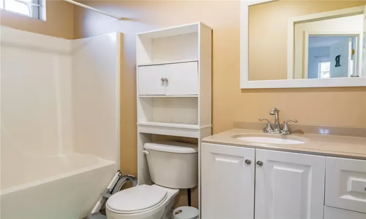 Full bathroom with toilet, vanity, and tub / shower combination