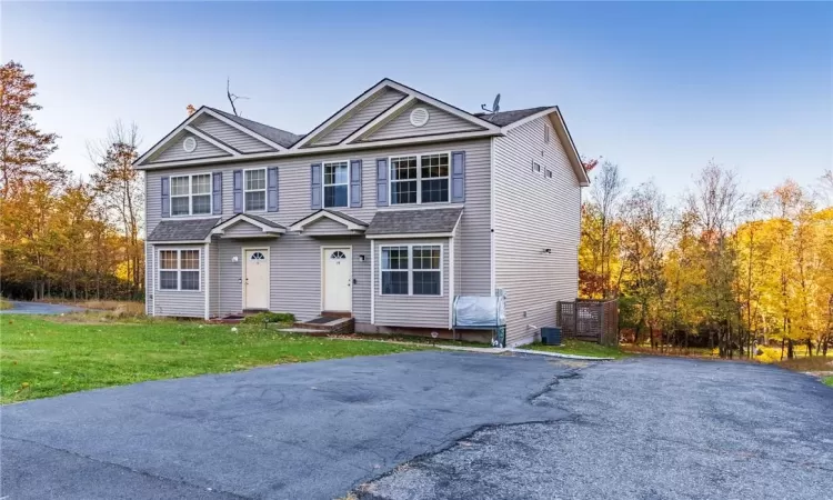 Front of property with a front yard and central AC unit