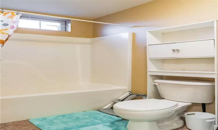 Bathroom featuring toilet and shower / tub combo