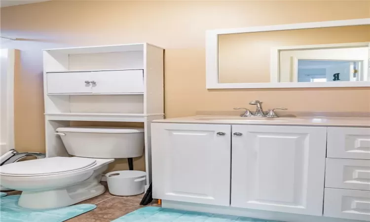 Bathroom with vanity, toilet, and tile patterned floors