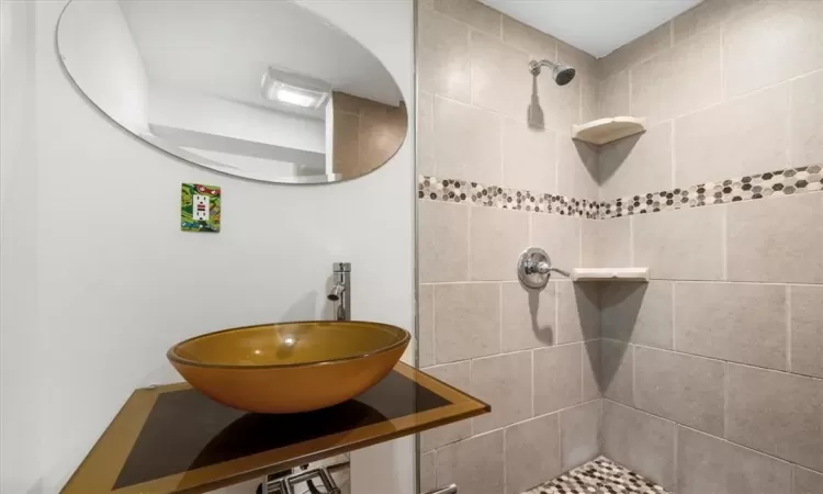 Bathroom featuring sink and tiled shower