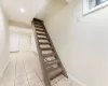 Stairway to lower level featuring tile patterned flooring