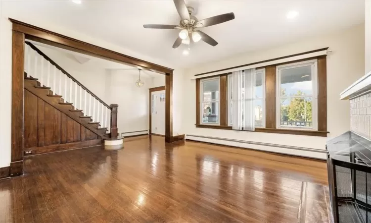 Living room featuring original hard wood floors and bannister and stairs leading to the 2nd floor.