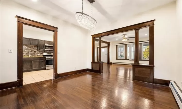 Dinning room with original hardwood floors and ornate wood columns. Chandelier stays.