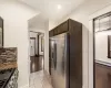 Kitchen featuring stainless steel refrigerator.