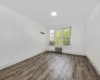 Unfurnished room with cooling unit, hardwood / wood-style flooring, and radiator