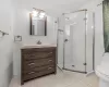 Bathroom with tile walls, walk in shower, toilet, tile patterned floors, and vanity