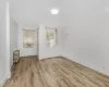 Unfurnished room with light hardwood / wood-style floors and radiator