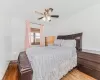 Bedroom with ceiling fan and hardwood / wood-style flooring