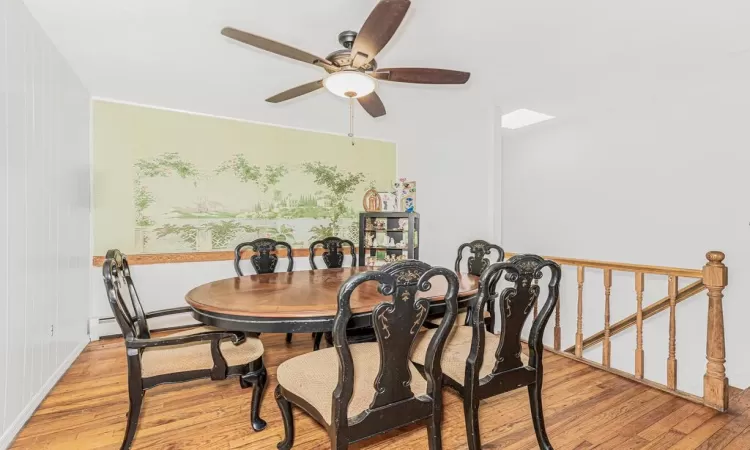 Dining area with light hardwood / wood-style floors, baseboard heating, and ceiling fan