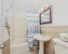 Bathroom featuring toilet, tile patterned floors, tile walls, and shower / tub combo