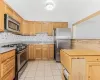 Kitchen featuring stainless steel appliances, sink, and light tile patterned flooring