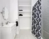 Bathroom featuring vanity, shower / bath combo with shower curtain, and tile patterned flooring