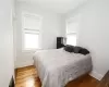 Bedroom featuring multiple windows and hardwood / wood-style flooring