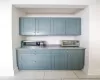 Bar with blue cabinets and light tile patterned floors