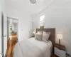 Bedroom with dark wood-type flooring and baseboard heating