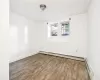 Unfurnished room with hardwood / wood-style flooring and a baseboard radiator