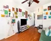 Living room with crown molding, hardwood / wood-style flooring, and ceiling fan