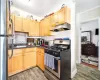 Kitchen with decorative backsplash, appliances with stainless steel finishes, ornamental molding, and dark hardwood / wood-style floors