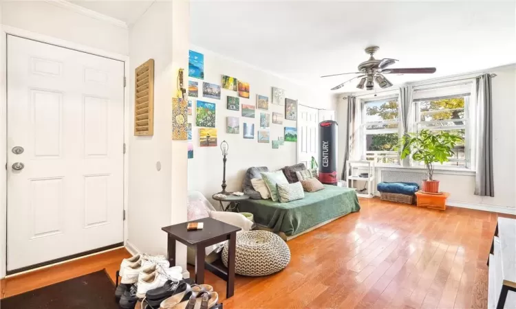 Sitting room featuring crown molding, wood-type flooring, and ceiling fan