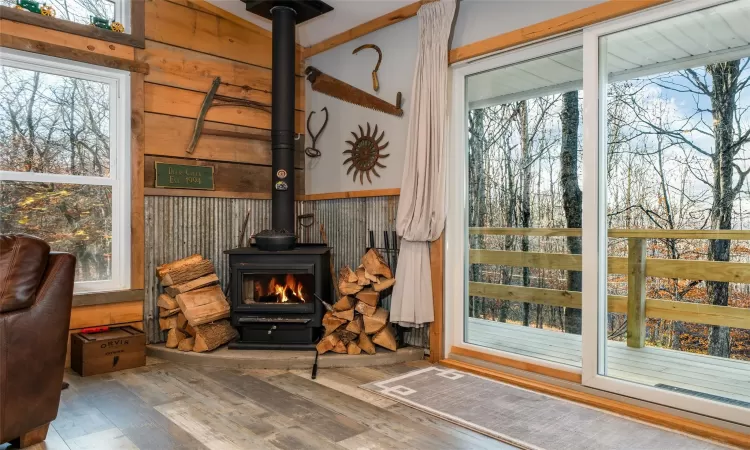 Living room featuring wood walls, wood-type flooring, and a wood stove