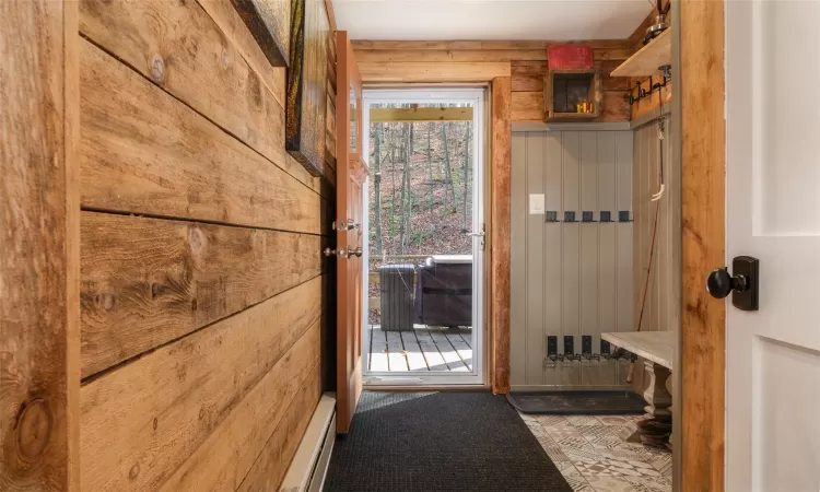 Mudroom with wooden walls and new tile.