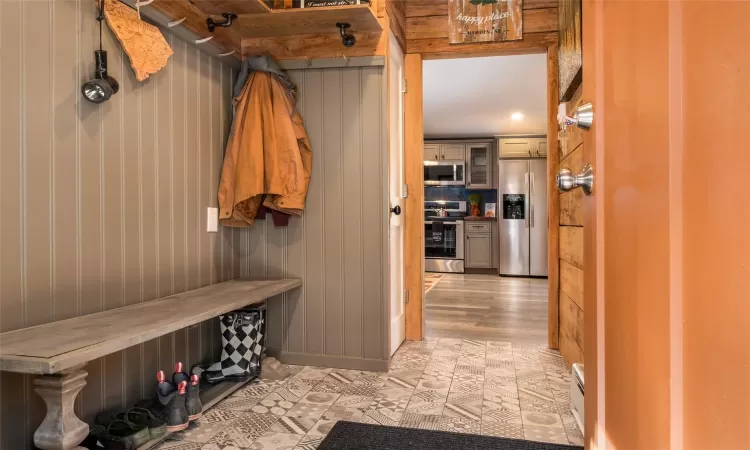 Mudroom with wood walls and light wood-type flooring