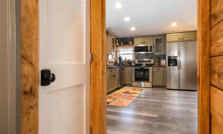 Kitchen with decorative backsplash, dark hardwood / wood-style flooring, and stainless steel appliances