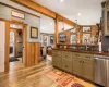 Kitchen featuring ceiling with beams, sink, stainless steel dishwasher, decorative light fixtures, and light hardwood / wood-style floors