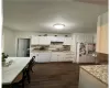 Kitchen with dark wood-type flooring, white cabinets, sink, tasteful backsplash, and white appliances