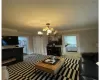 Living room featuring light colored carpet, a notable chandelier, and crown molding